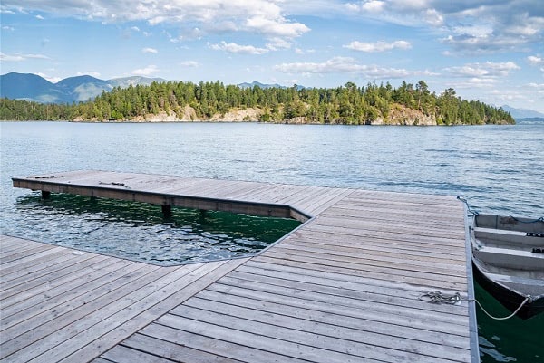 A lakefront hardwood deck made from Mataverde ThermaWood Hemlock decking material with a silvery gray patina weathering pattern.