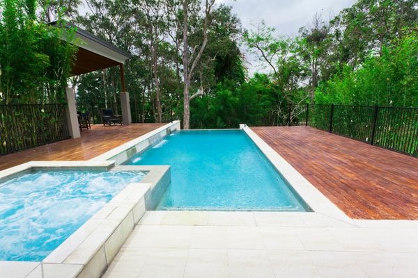 hardwood deck surrounding a pool and hot tub